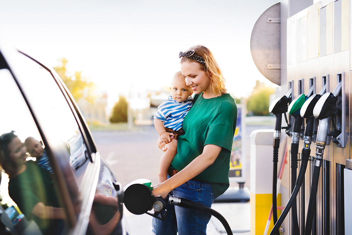 A woman charging her car at the gas station