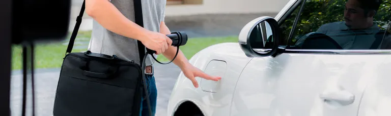 picture of a man charging a battery electric vehicle